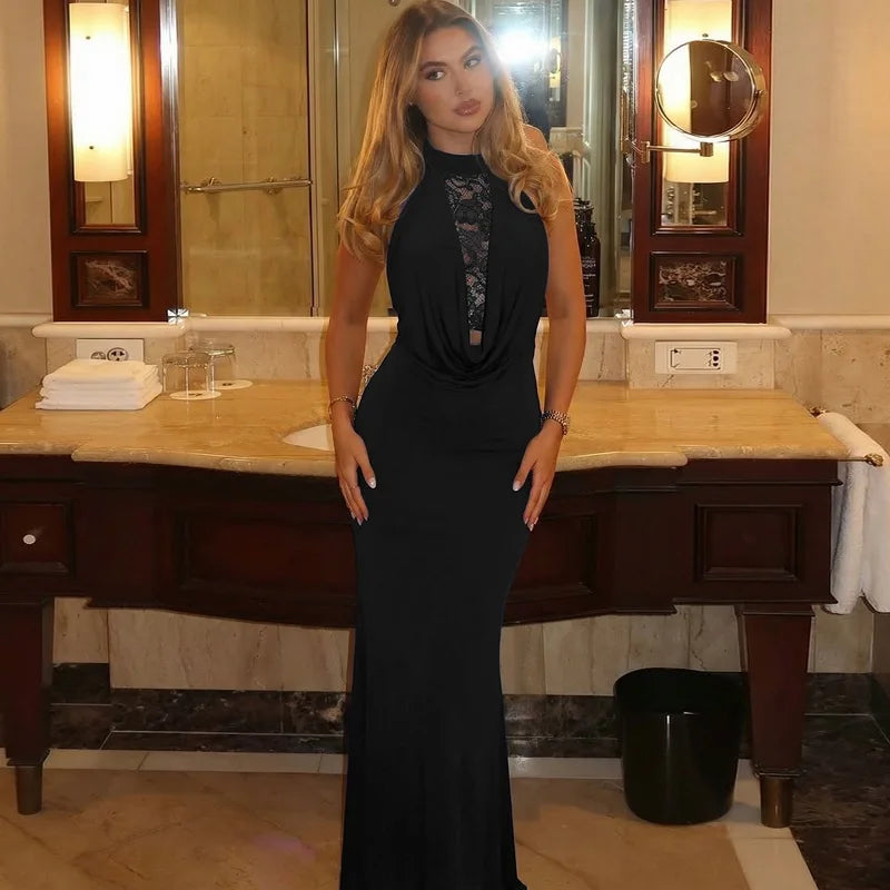 Woman in a black dress standing in a bathroom with wooden vanity and mirrors.