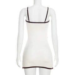 White dress with thin brown straps on a mannequin against a white background
