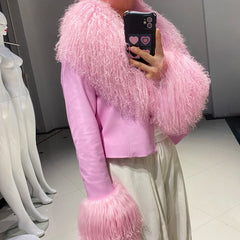 Person wearing a pink fluffy jacket taking a mirror selfie.