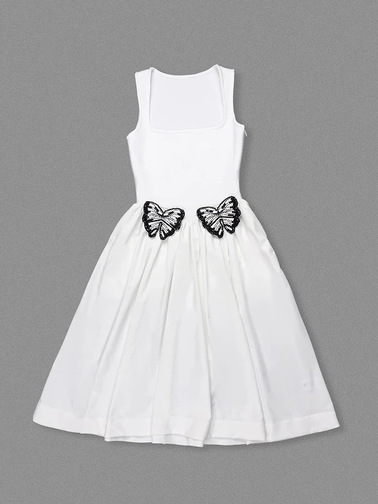 White dress with black butterfly decorations on a gray background