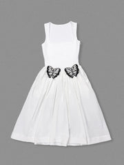 White dress with black butterfly decorations on a gray background