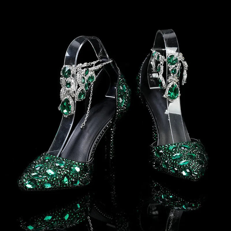High-heeled shoes with green gemstones on a black background