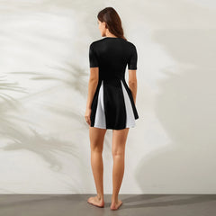 Woman wearing a black and white dress against a neutral background