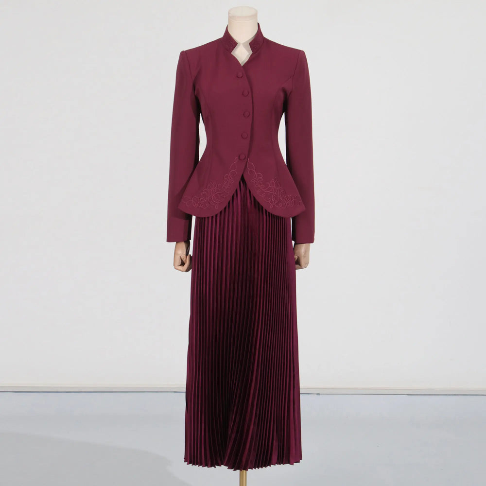 Maroon suit with a jacket and pleated skirt on a mannequin against a white background