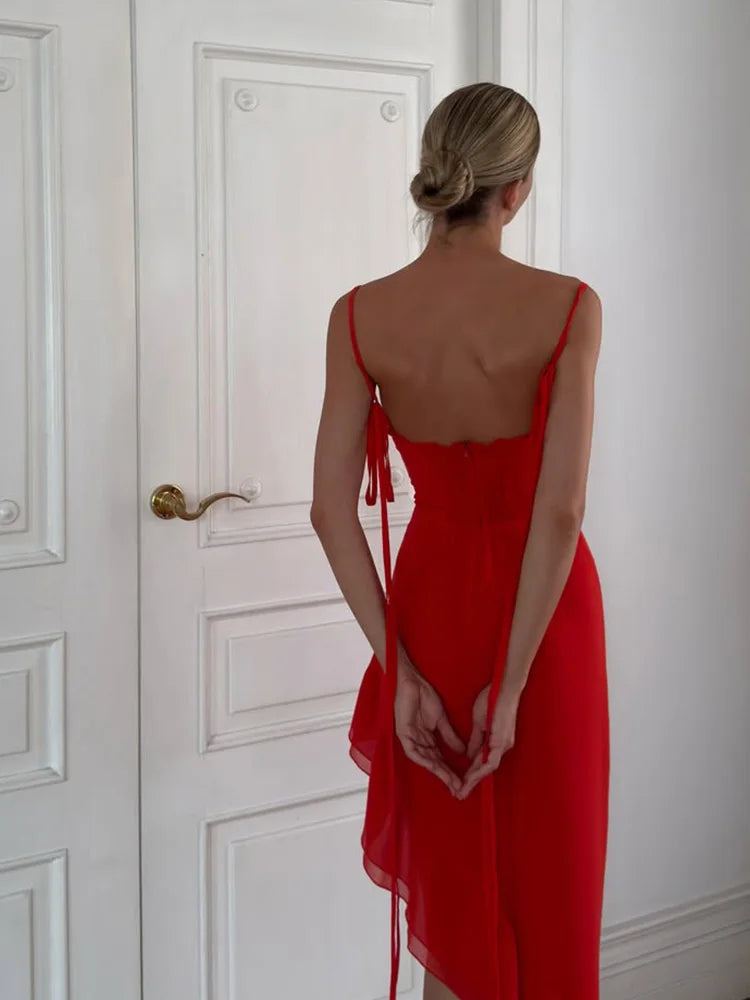 Woman in a red dress standing in front of a white door.