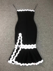 Black dress with white lace details on a gray surface