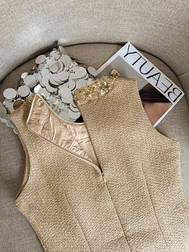 Beige sleeveless top with sequin details on a textured surface