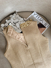 Beige sleeveless top with sequin details on a textured surface