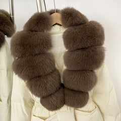 Brown fur scarf draped over a white coat on a hanger