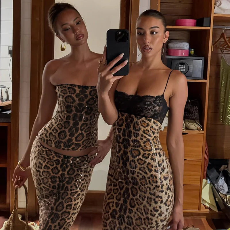 Two women in leopard print outfits taking a mirror selfie.