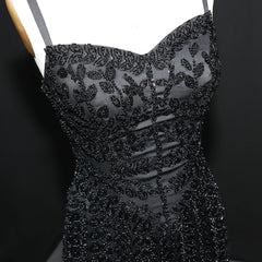 Black beaded dress on a mannequin against a dark background