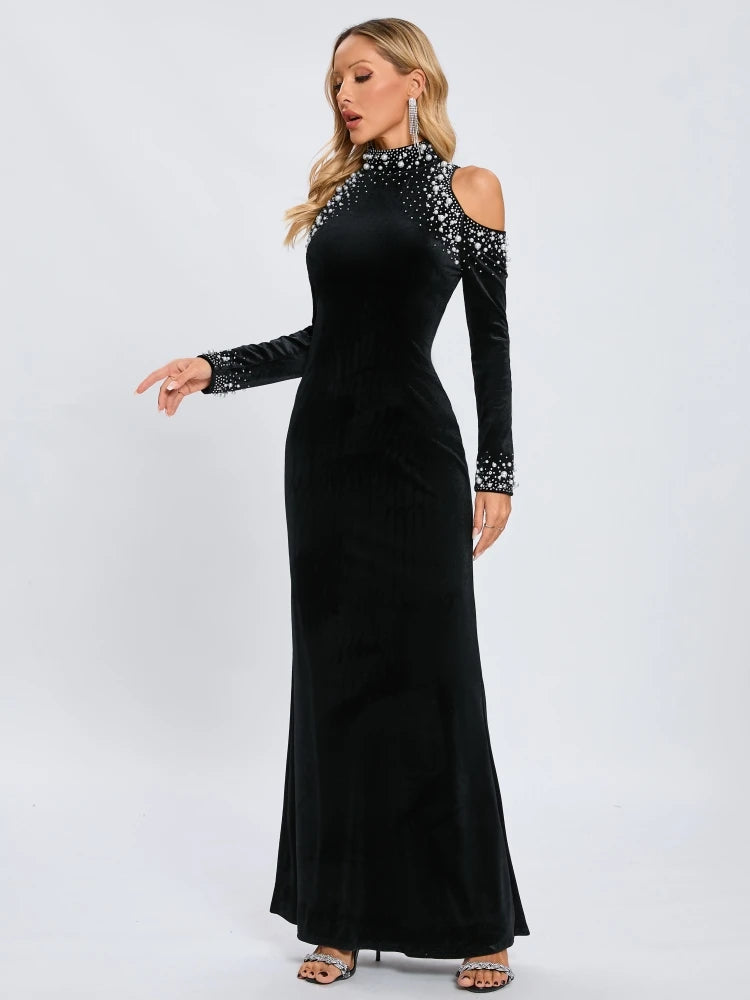 Black evening gown with long sleeves and beaded details on a white background