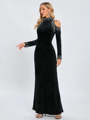 Black evening gown with long sleeves and beaded details on a white background