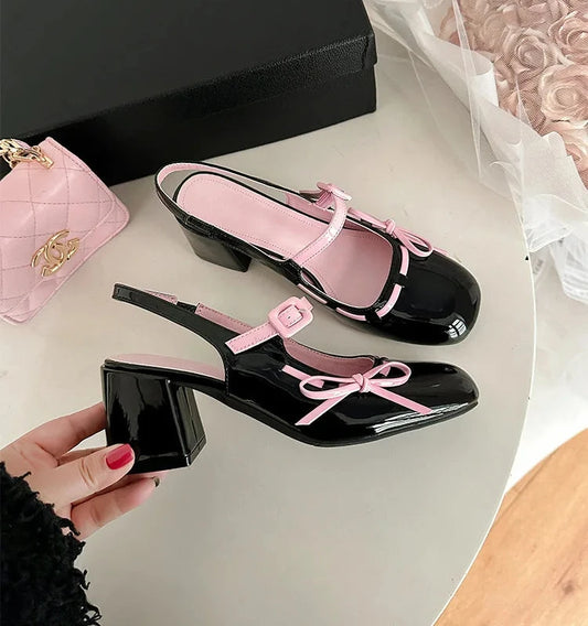 Black patent leather chunky Mary Jane heels with pink trim and bowknot detail.