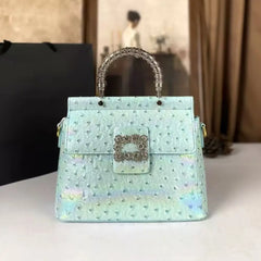 Light blue ostrich embossed top handle bag with crystal clasp and textured handle.