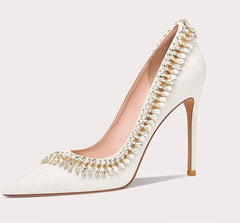 White high-heeled shoe with decorative elements on a light gray background