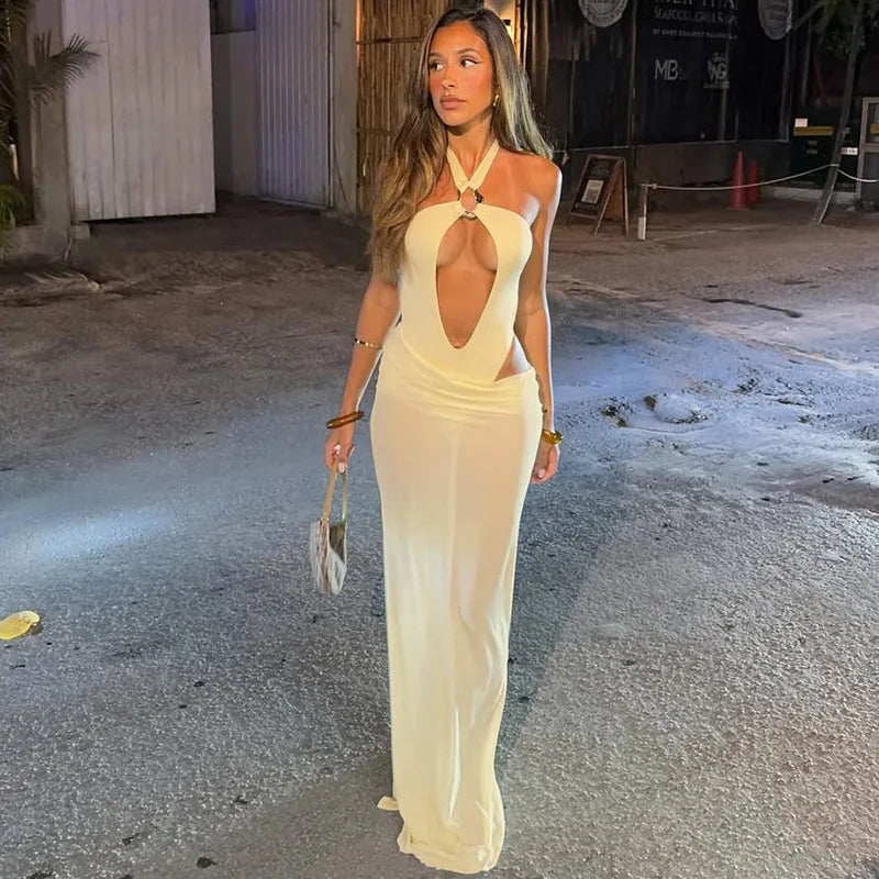 Woman in a white evening gown standing on a street.