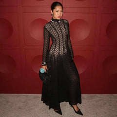 Woman in a black lace dress against a red wall