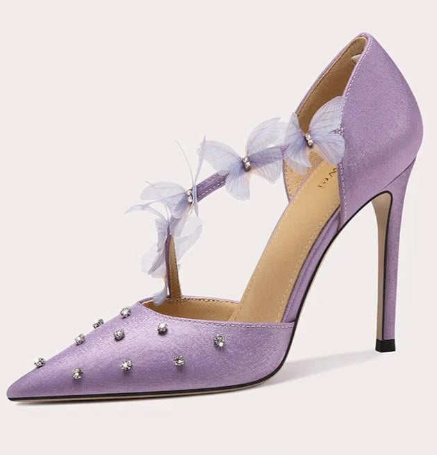 Purple high-heeled shoe with decorative elements on a light gray background
