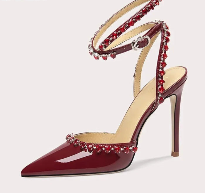 High-heeled shoe with red embellishments on a white background