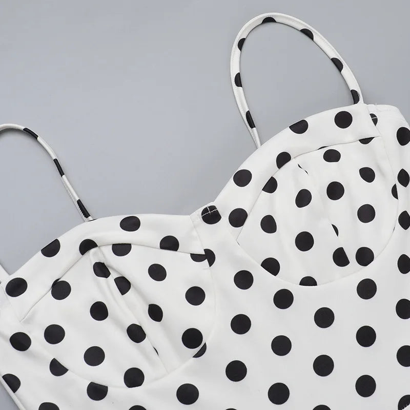 White top with black polka dots on a gray background