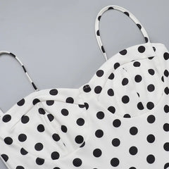 White top with black polka dots on a gray background
