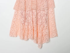 Close-up of the asymmetrical hem on a pink lace mini dress