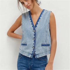 Model wearing a light wash embroidered denim vest.