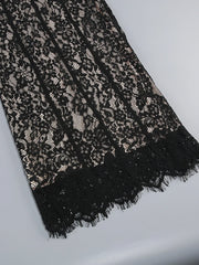 Black lace fabric on a light gray background