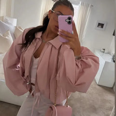 Mirror selfie of woman in pink balloon sleeve collared zip-front cropped jacket