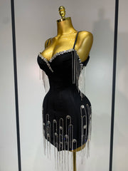 Black dress with silver fringe and embellishments on a mannequin against a neutral background