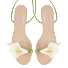 Beige sandals with white floral straps on a white background