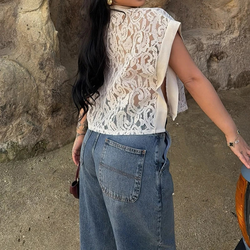 Back view of a lace mock neck sleeveless sheer crop top worn by a person outdoors.