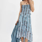 Woman wearing a floral dress with a denim jacket on a white background