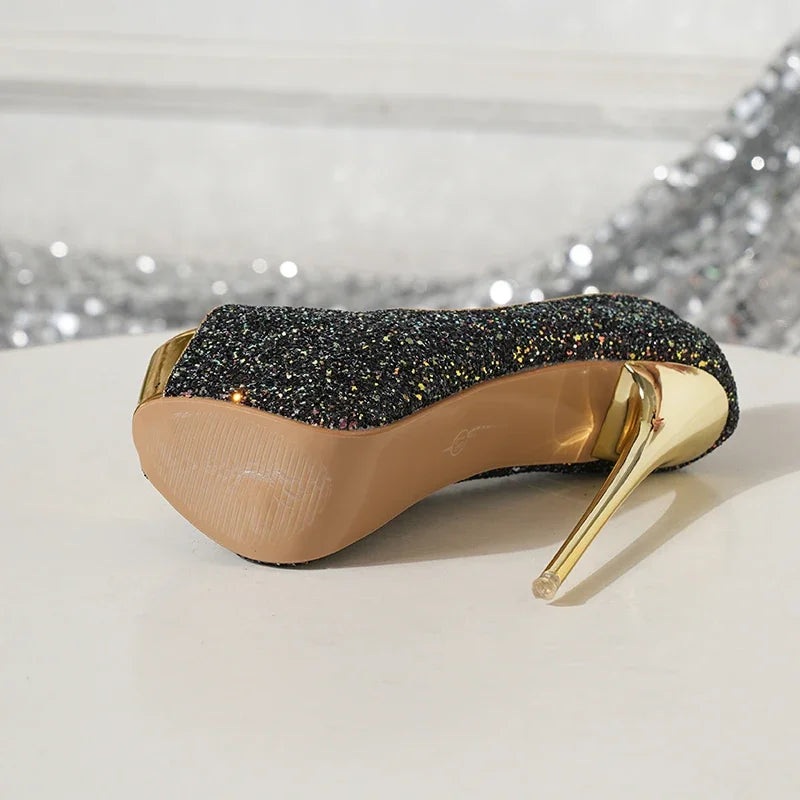 High-heeled shoe with glittery black sole and gold heel on a light background