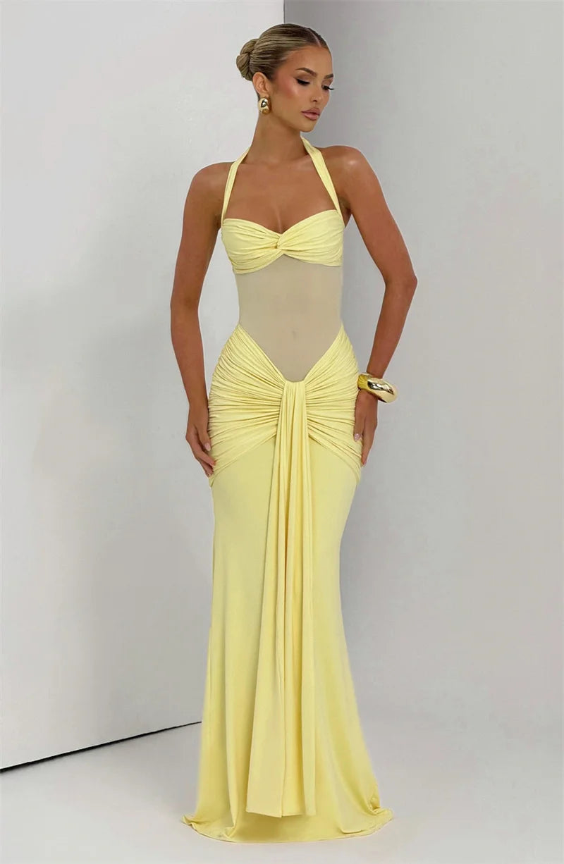 Woman wearing a yellow evening gown against a plain background