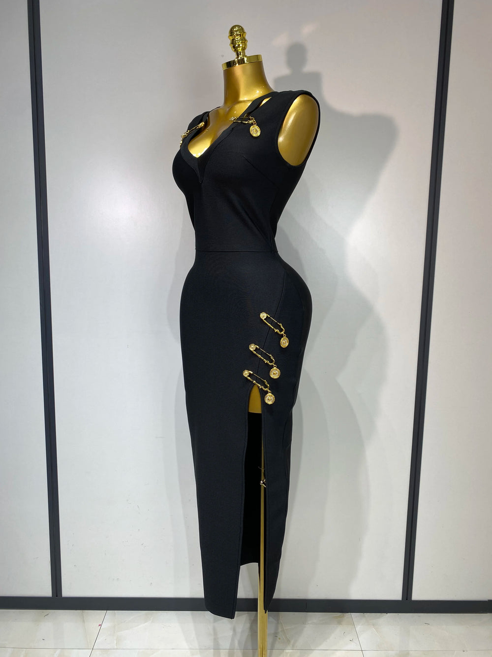 Black jumpsuit with gold accents on a mannequin against a white background
