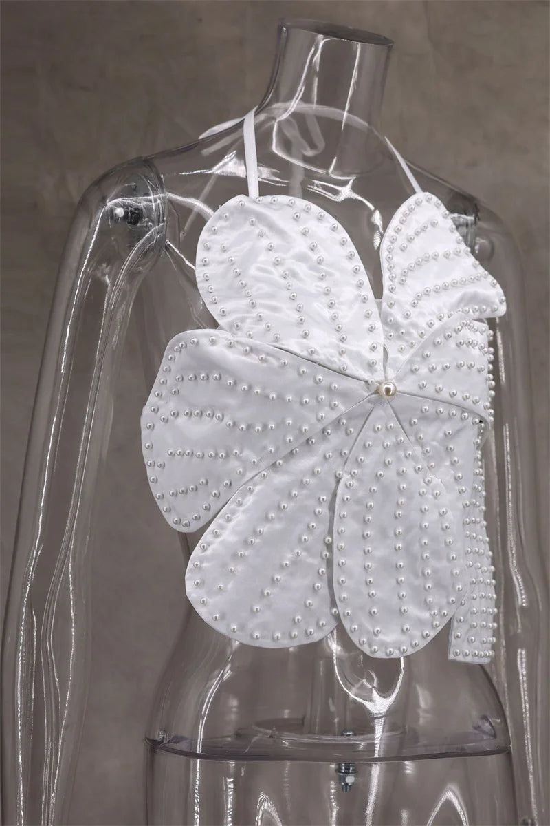White butterfly-shaped garment on a transparent mannequin against a neutral background