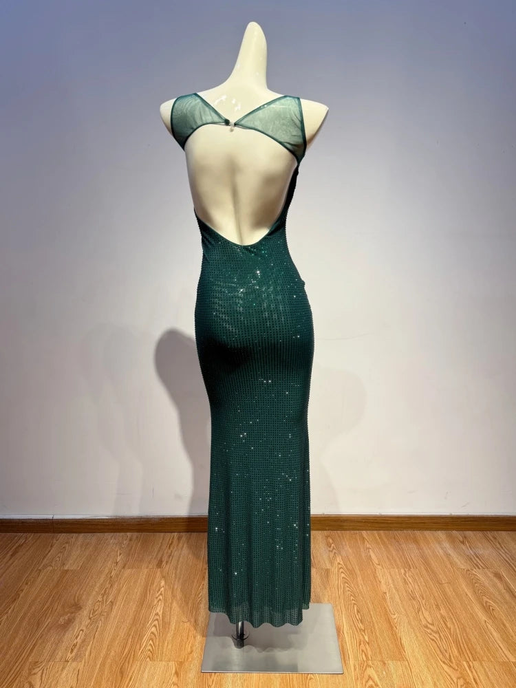 Green evening gown on a mannequin against a plain wall.