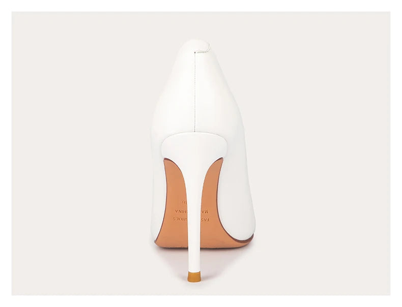 White high-heeled shoe with a tan sole on a light gray background