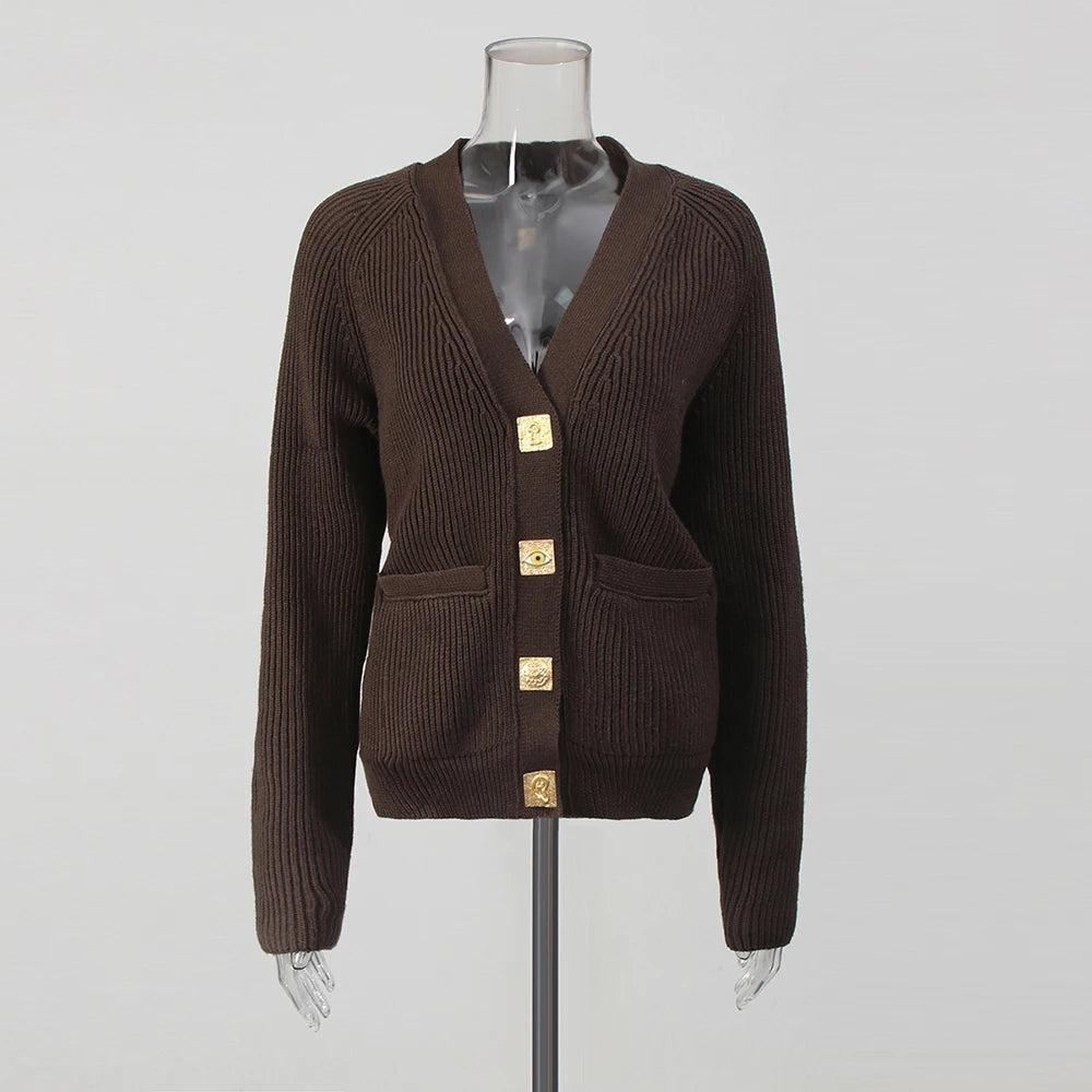 Brown cardigan with gold buttons on a mannequin against a gray background
