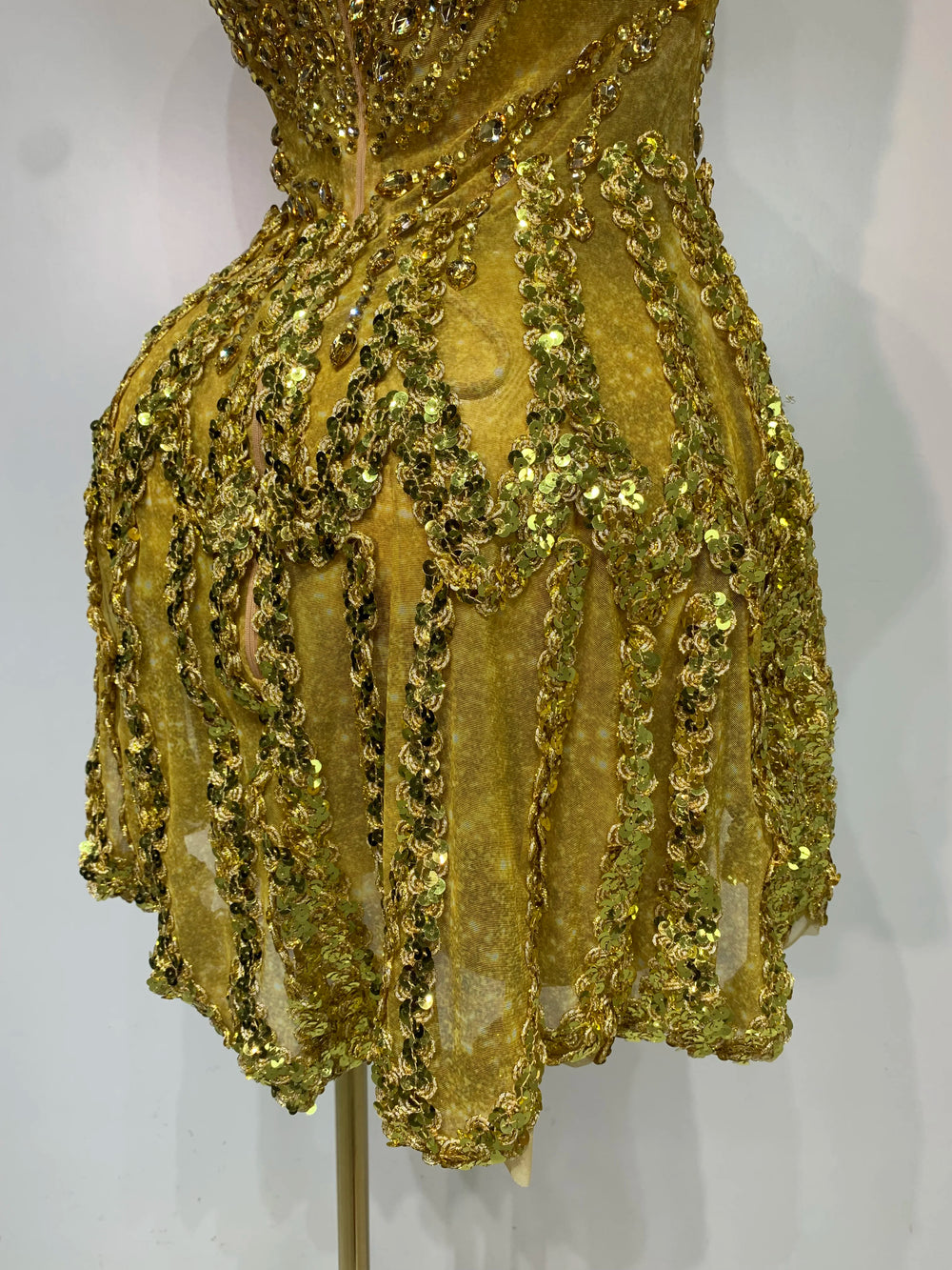 Close-up of gold sequined strapless mini dress hem