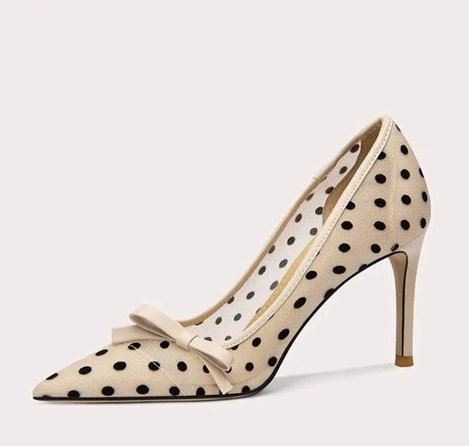 High-heeled shoe with polka dot pattern and bow detail on a white background