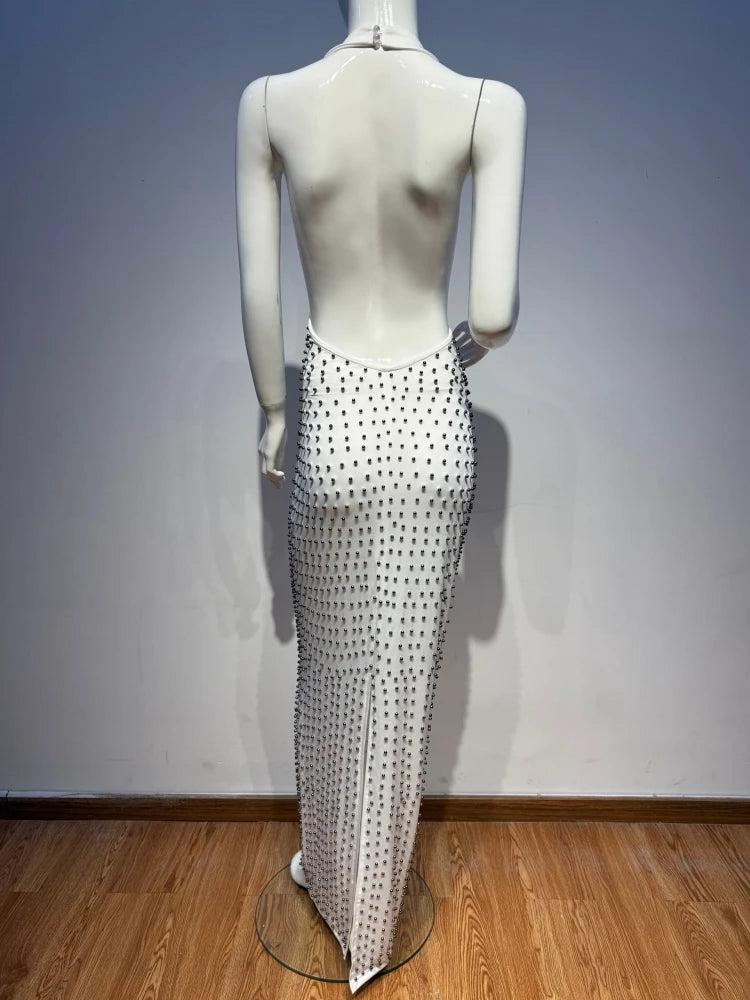 Mannequin wearing a long, sheer skirt with black polka dots on a wooden floor.