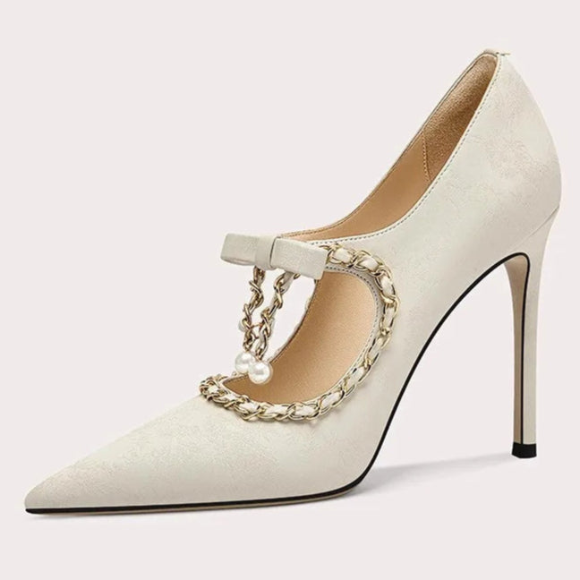 White high-heeled shoe with gold chain detail on a white background
