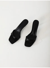 Pair of black high-heeled shoes on a light gray background