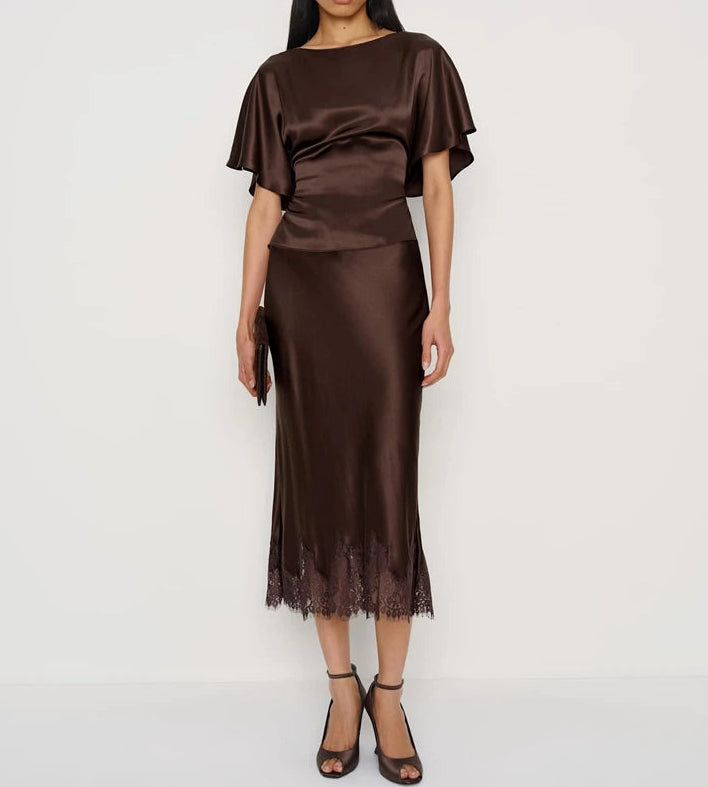 Woman wearing a brown satin outfit on a white background
