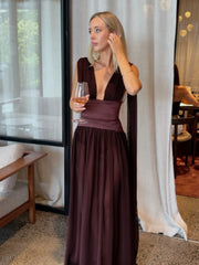 Woman wearing a deep v-neck maxi dress holding a wine glass