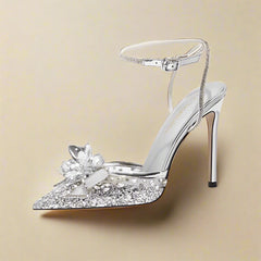 Silver high-heeled shoe with decorative flower on a white background