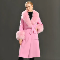 Woman wearing a pink coat with fur trim against a gray background
